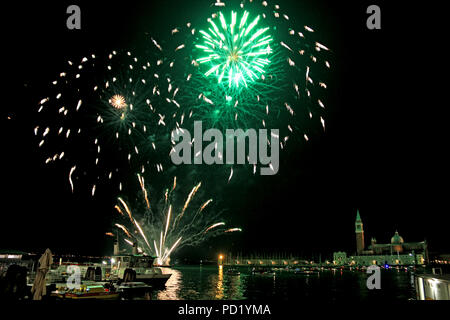 Capodanno fuochi d'artificio illuminano il cielo intorno alla laguna di Venezia, Venezia, Italia, con l'isola di San Giorgio Maggiore in background Foto Stock