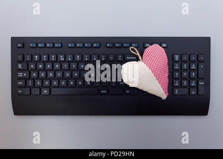 In tessuto rosso cuore sulla tastiera. Internet Dating concetto. Foto Stock