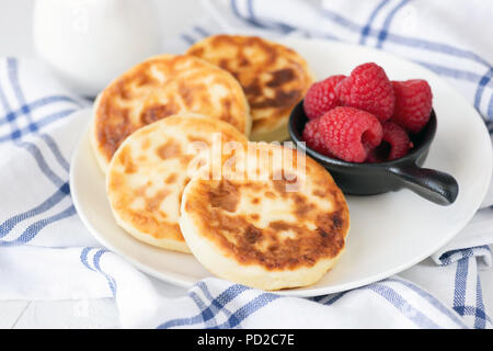 Cottage cheese pancakes sulla piastra bianca. Noto anche come syrniki, sirniki o ricotta frittelle. Cucina russa Foto Stock
