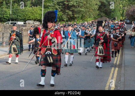 A Aberlour, Scozia - 06 August, 2018: bande di cornamuse marciando attraverso il villaggio dopo i Giochi delle Highland a Aberlour, Scozia. Foto Stock