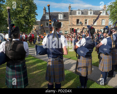 A Aberlour, Scozia - 06 August, 2018: bande di cornamuse a giocare nella piazza del paese dopo i Giochi delle Highland a Aberlour, Scozia. Foto Stock