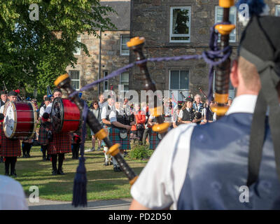 A Aberlour, Scozia - 06 August, 2018: bande di cornamuse a giocare nella piazza del paese dopo i Giochi delle Highland a Aberlour, Scozia. Foto Stock