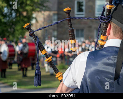 A Aberlour, Scozia - 06 August, 2018: bande di cornamuse a giocare nella piazza del paese dopo i Giochi delle Highland a Aberlour, Scozia. Foto Stock