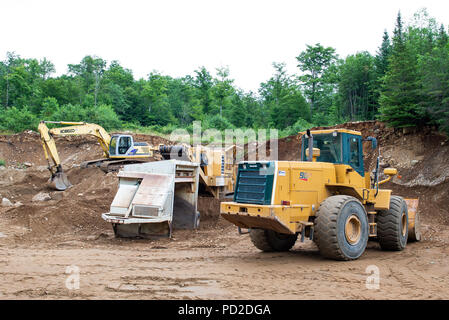 Macchinari pesanti lavorando in una spiaggia di sabbia e ghiaia pit nelle Montagne Adirondack, NY USA Foto Stock