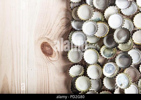 Un sacco di tappi di birra su una tavola di legno, vista dall'alto Foto Stock