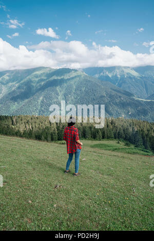 Solo femmina ragazza viaggiatore avventuriero in piedi sul bordo di una rupe a picco nella natura Foto Stock