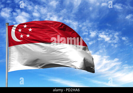 Bandiera Nazionale di Singapore su un pennone di fronte blu cielo. Foto Stock