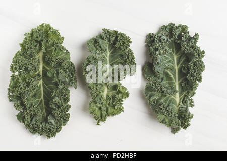 Foglie di cavolo verde su uno sfondo bianco. Vista superiore, copia dello spazio. Cibo sano sfondo, pulire il concetto di mangiare. Foto Stock