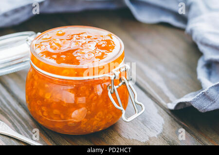 Vaso di vetro con cloudberry inceppamento. Cucina nordica. Foto Stock