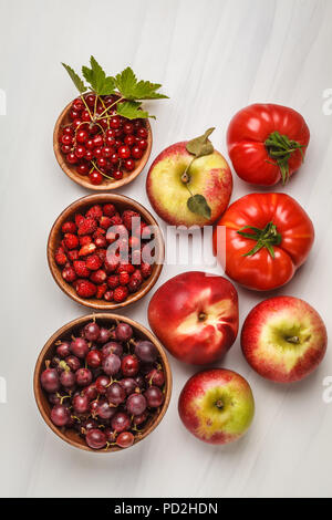 Assortimento di cibi di colore rosso su sfondo bianco, vista dall'alto. Frutta e verdura contenenti licopene. Sano cibo vegan sfondo. Foto Stock