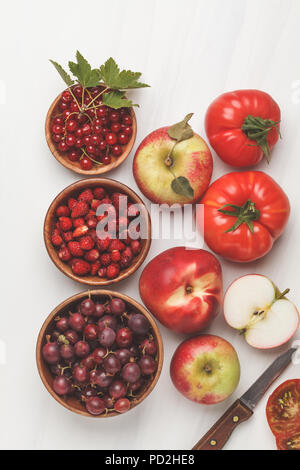 Assortimento di cibi di colore rosso su sfondo bianco, vista dall'alto. Frutta e verdura contenenti licopene. Sano cibo vegan sfondo. Foto Stock