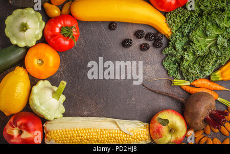 Colorati frutti, verdure e frutti di bosco su uno sfondo scuro. Pulire il concetto di mangiare, cibo vegan sfondo. Foto Stock