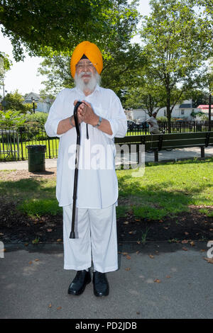 Un illustre uomo Sikh in tradizionali vestiti di bianco in un esterno di preghiera sessione in Smokey Park, Richmond Hill, Queens, a New York Foto Stock