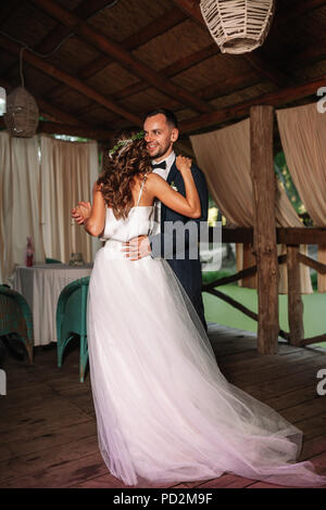 Felice sposa e lo sposo e il loro primo ballo, un matrimonio in un elegante ristorante con una splendida luce e l'atmosfera. Foto Stock