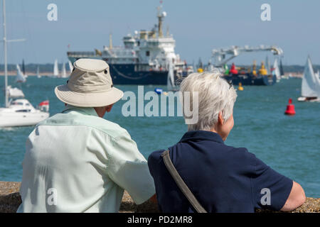 Un anziano o coppia di anziani l uomo e la donna a guardare le gare di yacht e la concorrenza a Cowes Week sull'isola di Wight. trinity house nave galatea Foto Stock