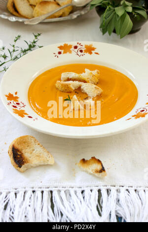 Vegano o CAROTA Crema di zucca Zuppa servita con crostini e timo. In stile rustico, il fuoco selettivo. Foto Stock