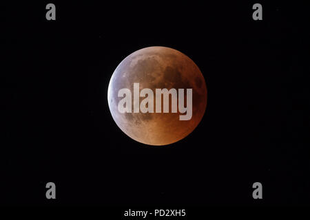 Super sanguinosa Luna, inizio della piena di eclipse fase finale contro il cielo stellato sfondo Foto Stock