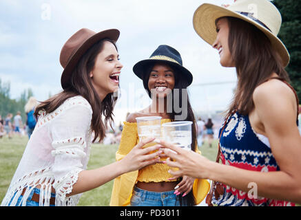 Gli amici a bere in festival di musica Foto Stock