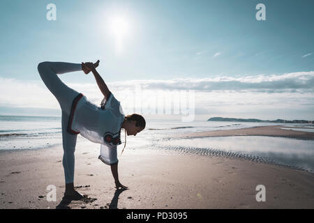 La donna a praticare yoga sulla spiaggia Foto Stock