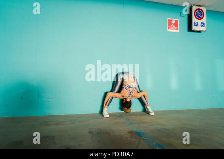 La donna a praticare yoga in parcheggio Foto Stock