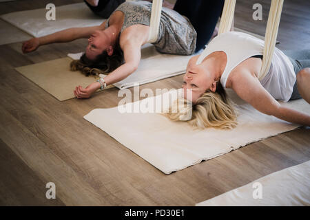 Le donne facendo yoga dell'antenna al ritiro Foto Stock