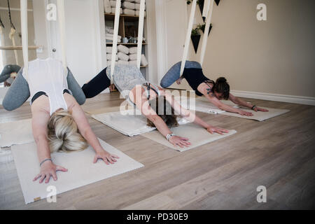 Le donne facendo yoga dell'antenna al ritiro Foto Stock