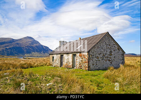 Vecchia capanna tradizionale in remoto la posizione brughiera, Sutherland, Highlands scozzesi, montagna di Ben pila in background, Scozia UK. Foto Stock
