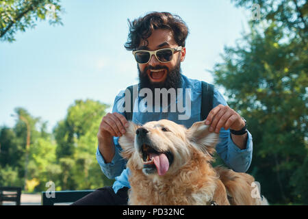 Uomo e cane divertendosi, giocando, facendo facce buffe mentre restin Foto Stock