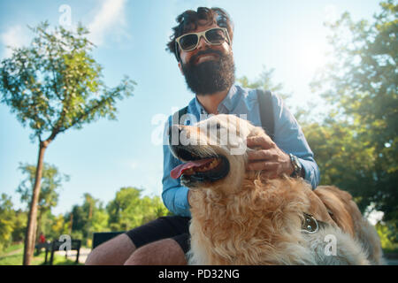 Uomo e cane divertendosi, giocando, facendo facce buffe mentre restin Foto Stock