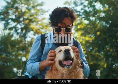 Uomo e cane divertendosi, giocando, facendo facce buffe mentre restin Foto Stock