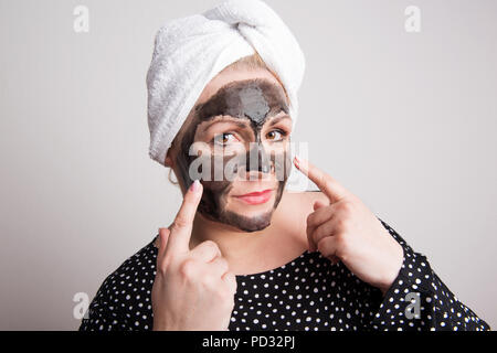 Un attraente Donna sovrappeso con nero maschera per il viso sulla sua faccia in un studio. Foto Stock