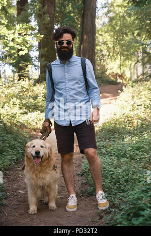 Uomo bello camminare il suo cane in all'aperto Foto Stock