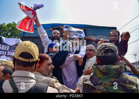 Il Kashmir. 6 agosto 2018. Membri del Kashmir alleanza economica gridare slogan nella parte anteriore di un veicolo della polizia durante una manifestazione di protesta contro la proposta di distacco dell'articolo 35a nello stato. La legge definisce quali residenti permanenti di stato possono acquistare e possedere proprietà e impedisce la non-locali da acquistare o il possesso di proprietà. Credito: Idrees Abbas SOPA/images/ZUMA filo/Alamy Live News Foto Stock