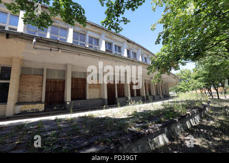 Wustermark, Germania. 06 Ago, 2018. Le finestre della sala da pranzo delle nazioni sono inchiodate con i pannelli presso l'ex villaggio olimpico dei Giochi Estivi del 1936. I lavori di ristrutturazione del villaggio su i limiti della città di Berlino sarà più costoso di quanto previsto in origine. "L'importo di 50 milioni di euro sarà certamente considerevolmente superato", ha detto un portavoce di terraplan. La società ha assunto una grande parte del sito. Credito: Wolfgang Kumm/dpa/Alamy Live News Foto Stock