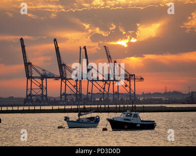 Queenborough, Kent, Regno Unito. Il 6 agosto, 2018. Regno Unito Meteo: il sole al tramonto, Queenborough, Kent. La gru di Thamesport sull'isola di Grain in distanza. Credito: James Bell/Alamy Live News Foto Stock