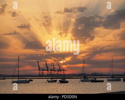 Queenborough, Kent, Regno Unito. Il 6 agosto, 2018. Regno Unito Meteo: il sole al tramonto, Queenborough, Kent. La gru di Thamesport sull'isola di Grain in distanza. Credito: James Bell/Alamy Live News Foto Stock