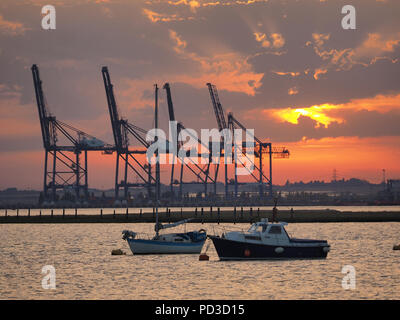 Queenborough, Kent, Regno Unito. Il 6 agosto, 2018. Regno Unito Meteo: il sole al tramonto, Queenborough, Kent. La gru di Thamesport sull'isola di Grain in distanza. Credito: James Bell/Alamy Live News Foto Stock