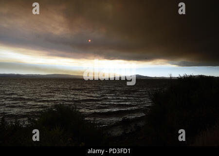 Ukiah, California, Stati Uniti d'America. Il 6 agosto, 2018. Ukiah, California, Stati Uniti - Il sole comincia a impostare attraverso il fumo dal Ranch Fire all'estremità settentrionale del lago. Credito: Neal acque/ZUMA filo/Alamy Live News Foto Stock