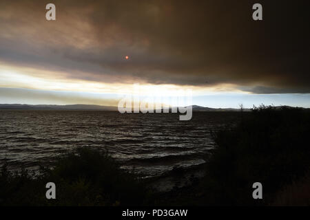 Ukiah, California, Stati Uniti d'America. Il 6 agosto, 2018. Il sole comincia a impostare attraverso il fumo dal Ranch Fire all'estremità settentrionale del lago. Credito: Neal acque/ZUMA filo/Alamy Live News Foto Stock