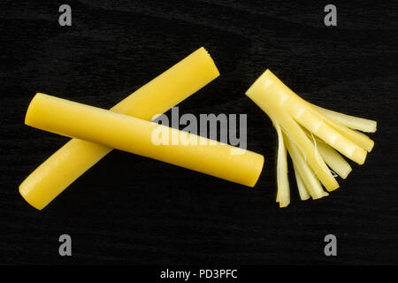 Gruppo di due tutto il pezzo di affumicato stringa slovacca formaggio flatlay stick in legno nero Foto Stock