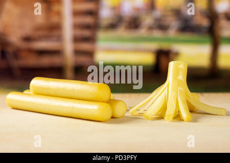 Gruppo di tre tutto il pezzo di affumicato stringa slovacca formaggio stick con carrello in background Foto Stock