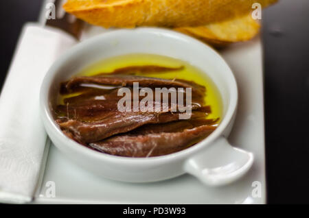 Deliziosi snack spagnolo, pesce fresco marinato in olio d'oliva, servita con crostini, tapas a base di pesce Foto Stock