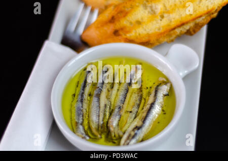 Deliziosi snack spagnolo, pesce fresco marinato in olio d'oliva, servita con crostini, tapas a base di pesce Foto Stock