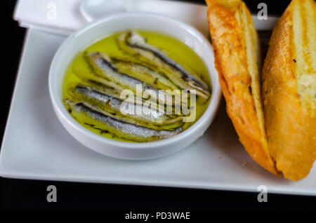 Deliziosi snack spagnolo, pesce fresco marinato in olio d'oliva, servita con crostini, tapas a base di pesce Foto Stock