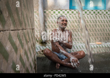 Uomo di lavaggio in un bagno pubblico spot, Calcutta, India Foto Stock