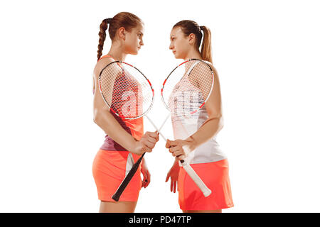 Le giovani donne prima di giocare a badminton in piedi su bianco di sfondo per studio. Montare le atlete isolato su bianco. confronto concept Foto Stock