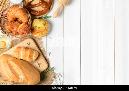 Pane casalingo o bun, croissant e Ingredienti per Pasticceria bianco su uno sfondo di legno, il cibo a colazione concetto vista superiore e spazio di copia Foto Stock