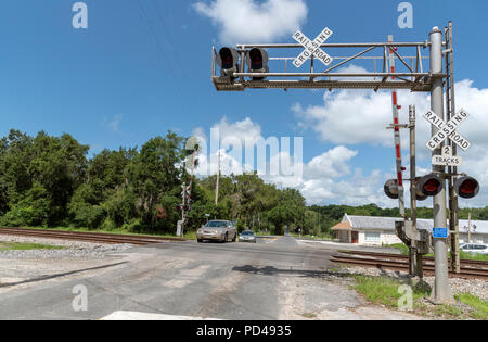 Summerfield, Florida, Stati Uniti d'America, 2018. I segnali ferroviari e la via che passa attraverso il North Florida campagna. Auto che attraversa la giunzione. Foto Stock