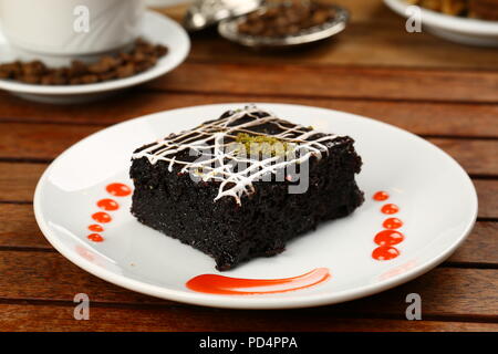 Square succosa spugna di cioccolato torta umida con la salsa in stampo e caffè Foto Stock