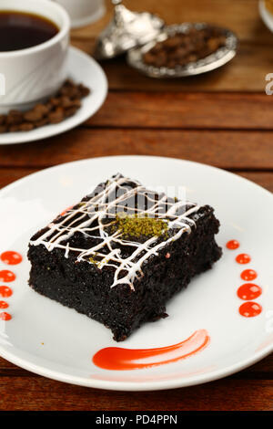 Square succosa spugna di cioccolato torta umida con la salsa in stampo e caffè Foto Stock